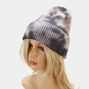 Detail of grey and pink tie-dye knit beanie showing core-spun yarn texture and rolled edge