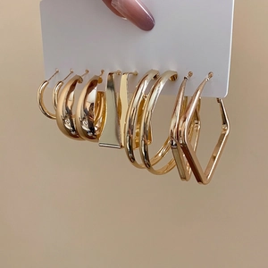 Polished gold geometric hoop earring set with minimalist metallic finish on white card