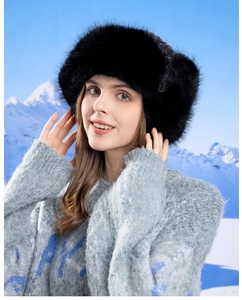Detail of fluffy black faux fur trapper hat with ear flaps for winter warmth protection