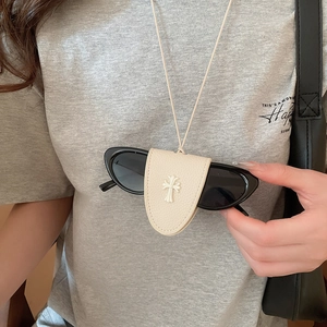 Close-up of a white leather magnetic glasses holder necklace with cross emblem