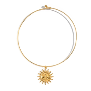 Detail of a 18K gold-plated sun face pendant on a sleek titanium steel choker necklace