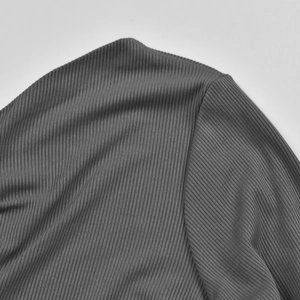 Macro detail of the dark grey ribbed knit fabric and seamless shoulder stitching