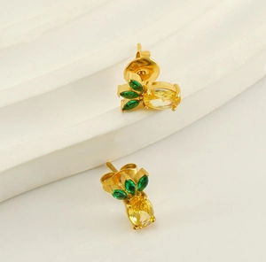 Detail of 18k gold plated pineapple stud earrings with yellow and green cubic zirconia
