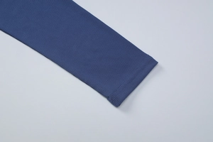 Gros plan du poignet en maille côtelée bleue avec coutures de haute qualité