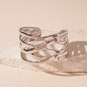 Detail of silver layered woven open cuff bracelet displayed on a natural white stone