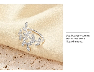 Detail of S925 silver leaf ring with 5A zircon stones on soft silk and stone background