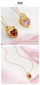 Close-up of crown heart pendants with red and pink gemstones on gold chains