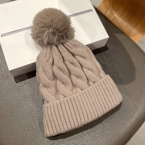 Thick cable knit beanie with faux fur pom-pom in light brown for winter warmth