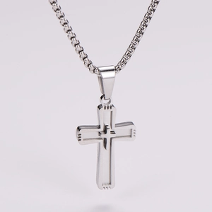Detailed view of silver double-layered cross pendant with box chain on white background