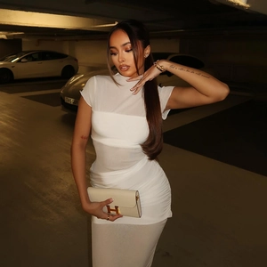 Detail of white sheer mesh bodycon dress with ruching and luxury gold buckle handbag