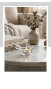 Macro shot of transparent glass bird candle holder on a marble table with soft lighting