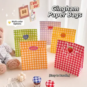 Five colorful checkered kraft paper gift bags with decorative stickers in a cozy room setting