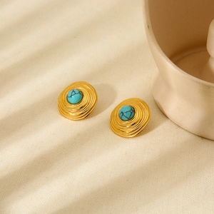 Retro gold plated stainless steel stud earrings with turquoise stones on beige texture