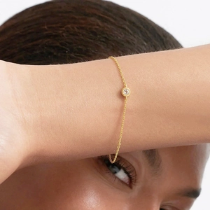 Close-up of elegant gold s925 silver bracelet featuring a four-prong set round zircon stone