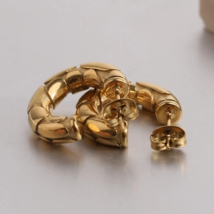 Detail of 18K gold-plated C-shape hoop earrings with embossed snakeskin texture