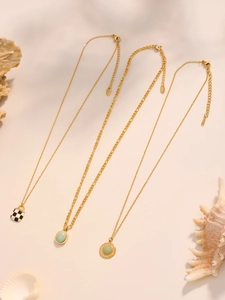 Detailed shot of gold turquoise and checkerboard pendants on seashell background