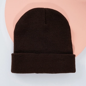 Gros plan sur la texture en maille fine et le revers de ce bonnet en tricot marron foncé