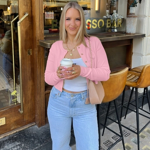 Gilet en maille rose ajusté pour femme avec haut blanc et jean bleu clair délavé