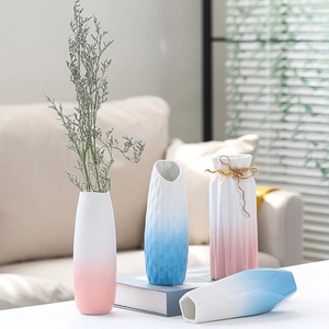 Close-up of textured ceramic vases in blue and pink gradients with hemp rope detail