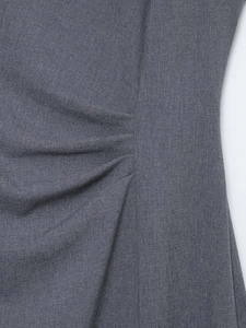 Gros plan sur les détails froncés et la texture du tissu d'une robe grise sans manches