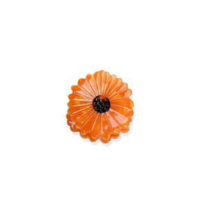 Vibrant orange sunflower hair claw clip with glossy finish on a clean white background