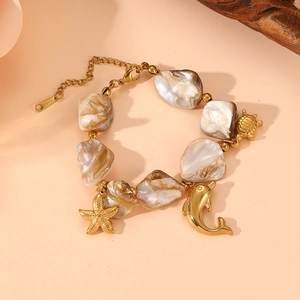 Detailed view of beach-themed bracelet with gold charms of turtle, starfish and dolphin