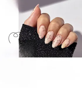 Detailed view of almond-shaped light pink press on nails featuring golden star patterns