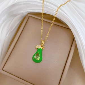 Detailed view of green teardrop leaf pendant with diamonds on elegant gold chain