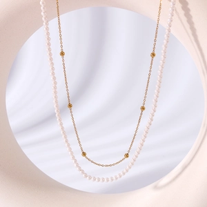 Double-layer necklace with elegant pearls and vintage metal bead chain on soft fabric