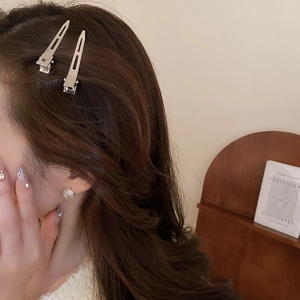 Détail de pinces à cheveux géométriques en métal argenté pour un look minimaliste chic
