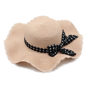 Women's wide brim straw sun hat with wavy edges and checkered ribbon bow for beach travel