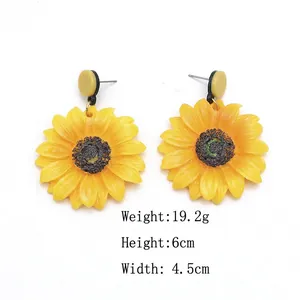 Sunflower drop earrings in bright yellow with measurements 6cm by 4.5cm on white backdrop
