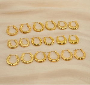 Macro shot of 9 pairs of gold hoop earrings with twisted and geometric textures