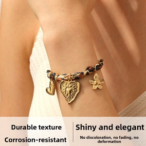 Dettaglio del bracciale a nastro leopardato con ciondoli a cuore e fiori dorati