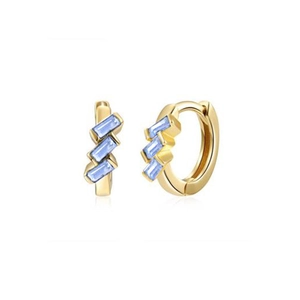 Macro shot of gold huggie earrings featuring three light blue baguette-cut crystals