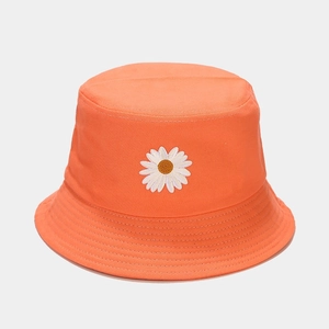 Detail of white daisy embroidery on vibrant orange cotton sun hat with neat stitching