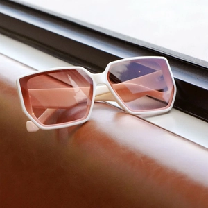 Retro white oversized square sunglasses with pink gradient lenses on brown leather