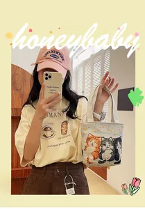 Detailed view of canvas tote bag with cat embroidery and casual fashion outfit styling