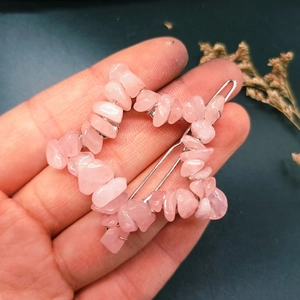 Star-shaped hair clip with pink natural crystal stones held by hand for detail