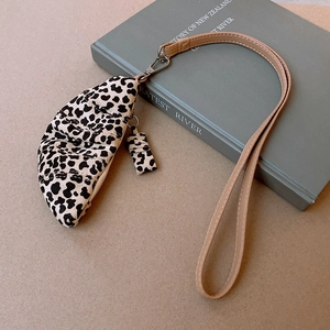 Detailed close-up of leopard print faux leather crescent bag with thin neck strap