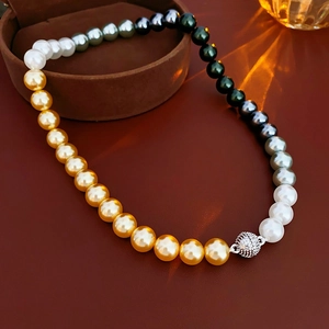 Detail of colorful pearl necklace with magnetic ball clasp on dark leather background