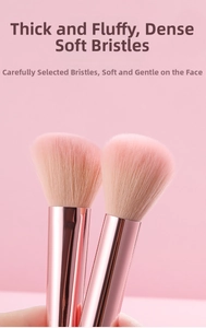Detailed view of peach pink makeup brushes with dense fibers and rose gold ferrules