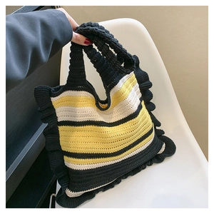 Detail view of handmade knitted tote bag with black yellow stripes and ruffle trim