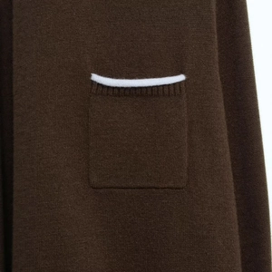 Elegant knit cardigan with contrasting white trim on dark brown pockets and soft texture