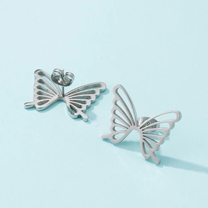 Vue macro de boucles d'oreilles papillon ajourées en acier argenté sur fond bleu
