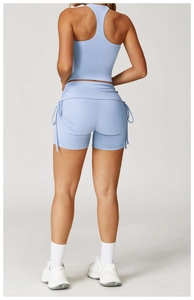 Detail of light blue racerback sports bra and drawstring side shorts on a model
