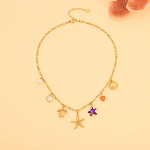 Detailed view of golden ocean-themed necklace with turtle starfish and shell charms