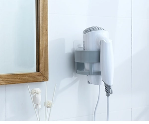 Detail view of wall-mounted hair dryer holder with cable hook in grey bathroom setting