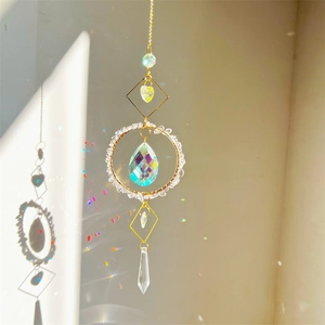 Crystal suncatcher with gold geometric frame and natural stones creating rainbow reflections