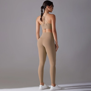 Detail of tan yoga set showing criss-cross back sports bra and high waist leggings